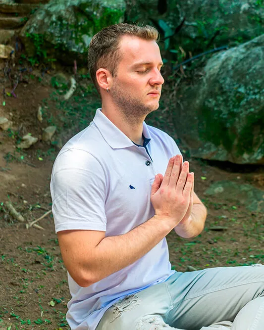 Guilherme Biotto meditando em posição de silêncio e presença, representando o caminho do Vibrar da Alma.